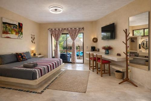 een slaapkamer met een bed, een bureau en een keuken bij Atenea Holbox in Holbox Island