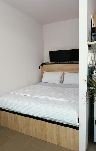 a bed with a wooden frame and white sheets at Molfar in Yasinya