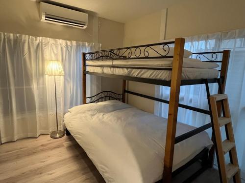 a bedroom with two bunk beds and a lamp at Cozy inn 西品川101 in Tokyo