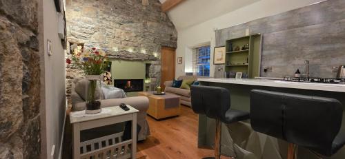 a kitchen and living room with a stone wall at The Burren, Cozy Cottage, County Clare in Carran