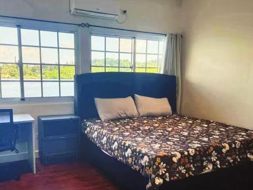 una camera da letto con un letto con testiera blu e finestre di Koror ocean view a Koror