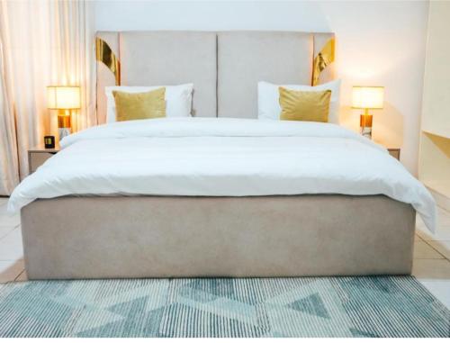 een slaapkamer met een groot wit bed met twee lampen bij Bito luxury - Wuse ll in Abuja