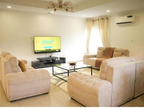 een woonkamer met twee banken en een flatscreen-tv bij Bito luxury - Wuse ll in Abuja