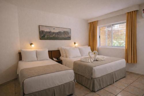 a hotel room with two beds and a window at Aguas do Iguaçu Hotel Centro in Foz do Iguaçu