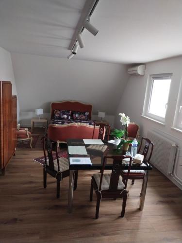 een woonkamer met een tafel, stoelen en een bank bij Les vignobles d'Alsace in Wintzenheim