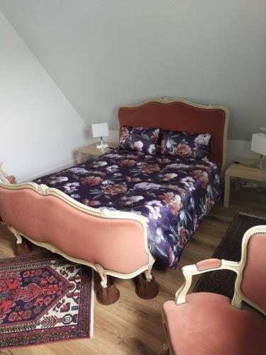 een slaapkamer met een bed en twee stoelen bij Les vignobles d'Alsace in Wintzenheim