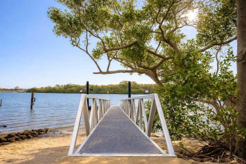 eine Holzbrücke über einen Wasserkörper in der Unterkunft Waterfront Coomera Escape in Gold Coast