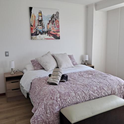 a bedroom with a bed and a painting on the wall at Departamento Los Carrera Centro in Osorno