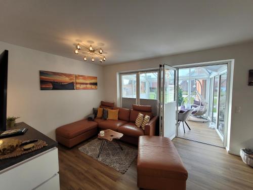 a living room with a couch and a table at Sonneninsel Wiek mit eigener Sauna und Fahrradgarage inkl Wäschepaket in Wiek auf Rügen