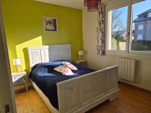 een meisje op een bed in een slaapkamer bij BRUYERE D'ANDAINE in Bagnoles de l'Orne