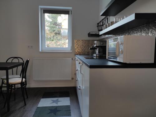 a kitchen with a counter and a table and a window at Garden Home in Törökbálint