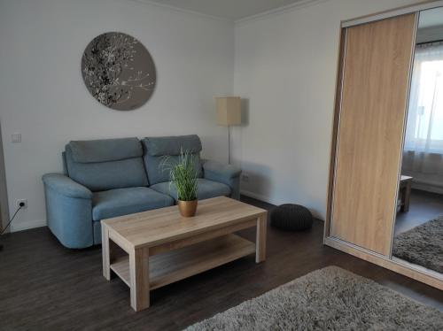 a living room with a blue couch and a coffee table at Garden Home in Törökbálint