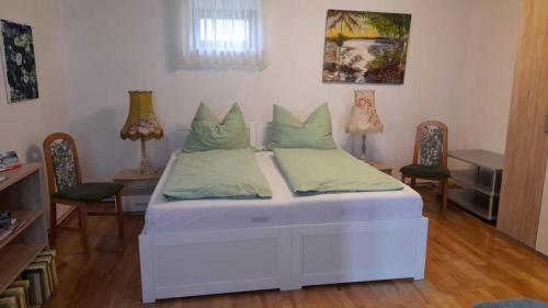 een wit bed in een kamer met 2 stoelen bij Haus Lüftleck in Lunz am See