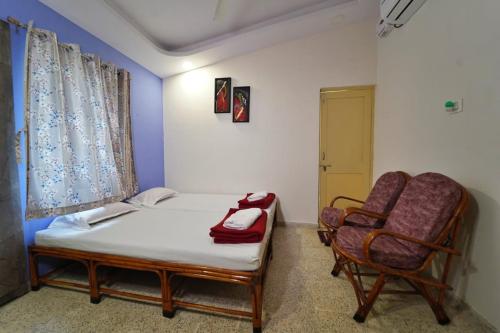 a bedroom with a bed and a chair in it at Arpan Villa in Aurangabad