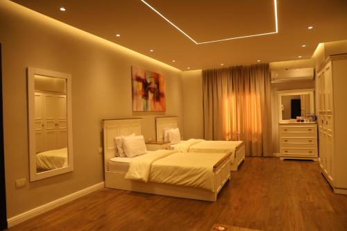 a bedroom with two beds and a mirror at Munir`s residence 2 in Cairo