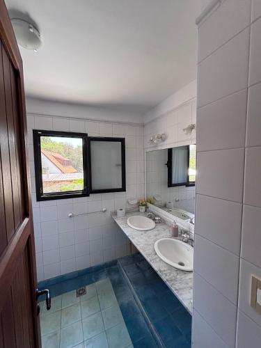 a bathroom with two sinks and a window at Beach House AP in Miramar