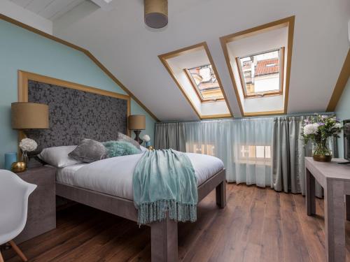 布拉格的住宿－布拉格華麗酒店，一间卧室设有一张床和两个窗户。