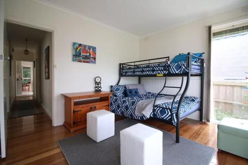 una camera da letto con un letto a castello e una scrivania di Rosebud Comfort Retreat a Rosebud