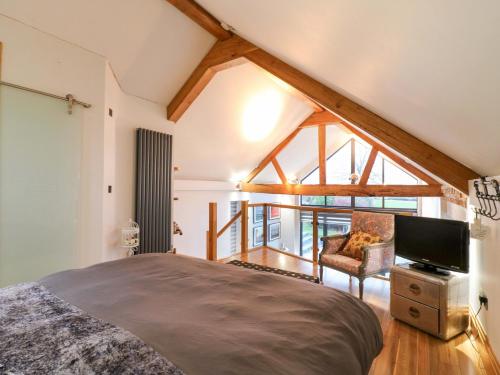 a bedroom with a bed and a tv in a room at The Lodge Lodge Farm in Bedford