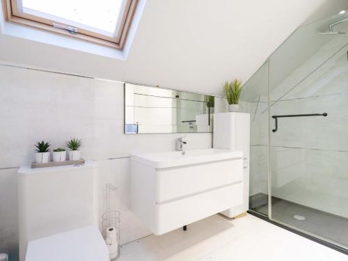 a white bathroom with a sink and a shower at The Lodge Lodge Farm in Bedford