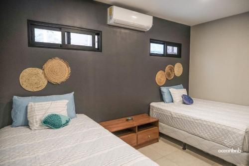 a bedroom with two beds and two windows at Cala los Mangos in Tamanique
