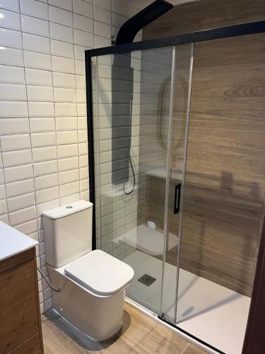a bathroom with a toilet and a glass shower at Villa Palma Cabo Roig 31a in Orihuela Costa