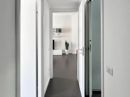 a hallway with white walls and a hallway with a mirror at Luxury Apartment in Crotone