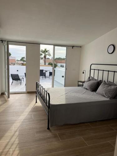 a bedroom with a large bed and a balcony at Villa Palma Cabo Roig 31a in Orihuela Costa