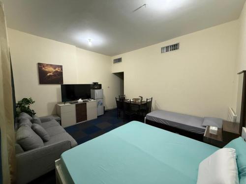 een woonkamer met een bank en een tv bij Ghurfati in Abu Dhabi
