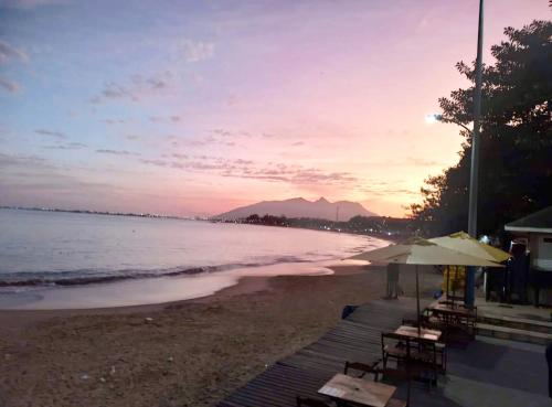 een strand met stoelen en parasols bij zonsondergang bij Aconchego do mar II in Rio das Ostras