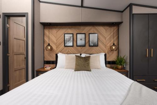 a bedroom with a large bed with white pillows at Clumber Park Lodges in Worksop