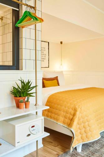 a bedroom with a bed with a yellow bedspread at Max Brown Hotel Midtown, part of Sircle Collection in Düsseldorf