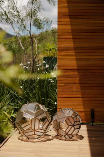 two metal sculptures sitting on a wooden deck at Bowi Hotel Conceito in Tiradentes