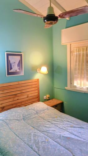 een slaapkamer met een bed en een plafondventilator bij Duplex Gesell in Villa Gesell