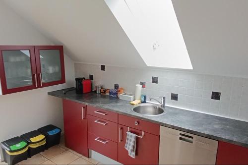 eine Küche mit roten Schränken und einer Spüle in der Unterkunft Panoramablick, ruhiger Lage, 20 Min nach Köln - EVARIS Hilda in Overath