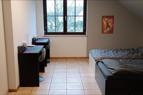 Zimmer mit 2 Schreibtischen, einem Bett und einem Fenster in der Unterkunft Panoramablick, ruhiger Lage, 20 Min nach Köln - EVARIS Hilda in Overath