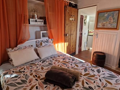- une chambre avec un grand lit et un rideau orange dans l'établissement Maison de village vençoise, à Vence