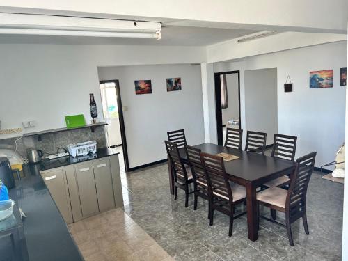 une cuisine et une salle à manger avec une table et des chaises dans l'établissement Coconut House, à Albion