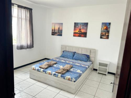 un lit dans une chambre avec des tableaux sur le mur dans l'établissement Coconut House, à Albion