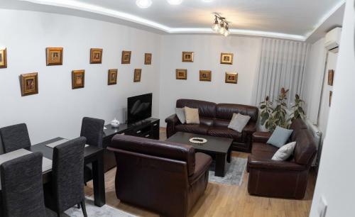 een woonkamer met leren meubels en een tafel bij Apartman Nana in Vranje