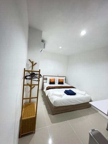a white bedroom with a bed and a ladder at Patong Beach Verve in Patong Beach