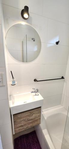 a bathroom with a sink and a mirror and a tub at EmBruHadas Violet in San Salvador de Jujuy
