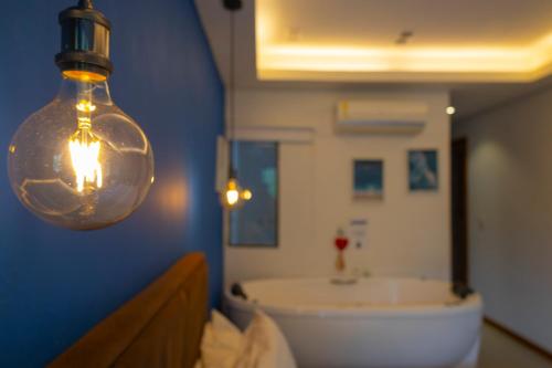 een badkamer met een lamp en een badkuip bij Casanova Residence - Barra da Tijuca na Ilha da Gigoia in Rio de Janeiro