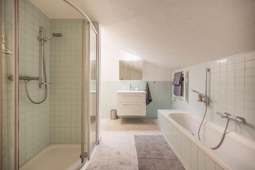 a bathroom with a shower and a tub and a sink at Katja's Loft in Neustift im Stubaital