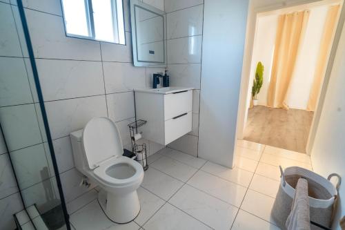 een witte badkamer met toilet en douche bij Luxury Apt with Amazing Views in Saint Johnʼs