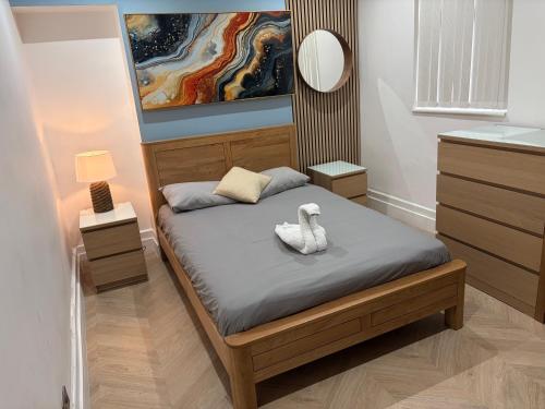 ein Schlafzimmer mit einem Bett mit zwei weißen Schuhen darauf in der Unterkunft Hendham Rooms in Manchester