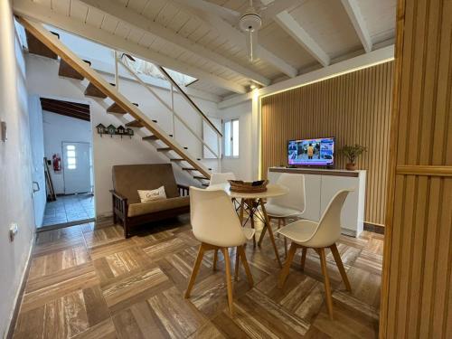 a living room with a table and chairs and a staircase at Raíces Pampas in Azul