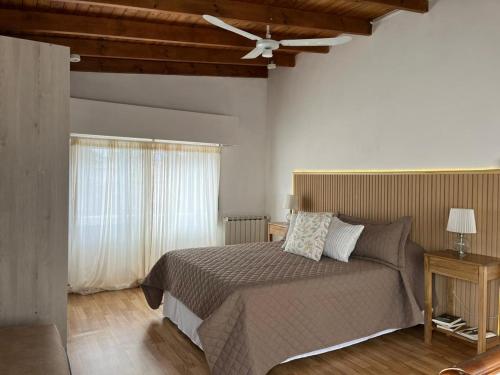 a bedroom with a bed and a ceiling fan at Raíces Pampas in Azul