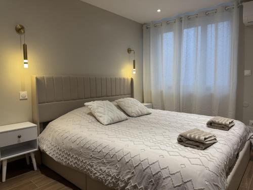 ein Schlafzimmer mit einem Bett, auf dem zwei Handtücher liegen in der Unterkunft L'Hakuna II - Suite et Spa in Fontaine-Notre-Dame