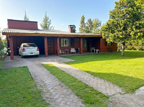 une maison avec une voiture garée devant dans l'établissement Casa Quinta Chascomús, à Chascomús